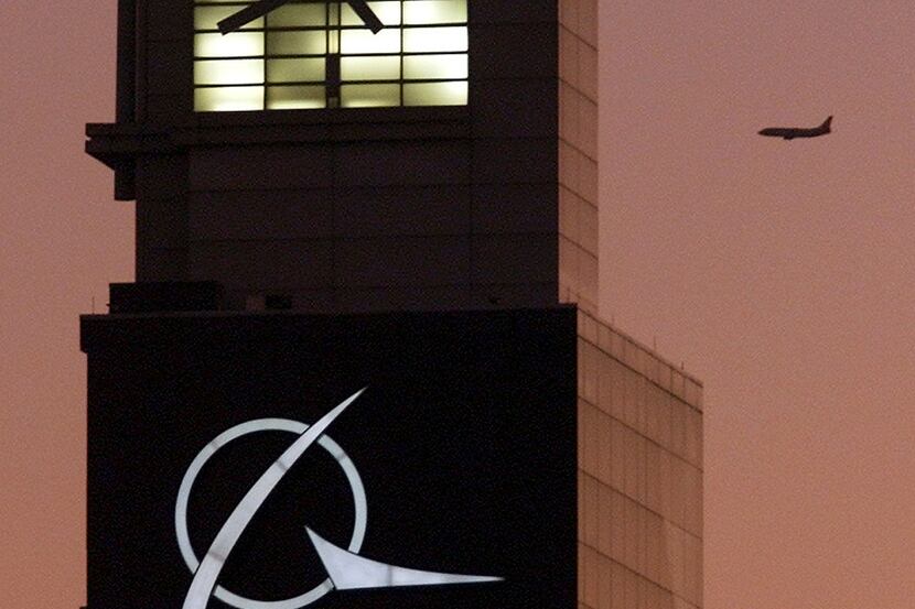 An airplane flies past the Boeing logo on the company's headquarters in Chicago.