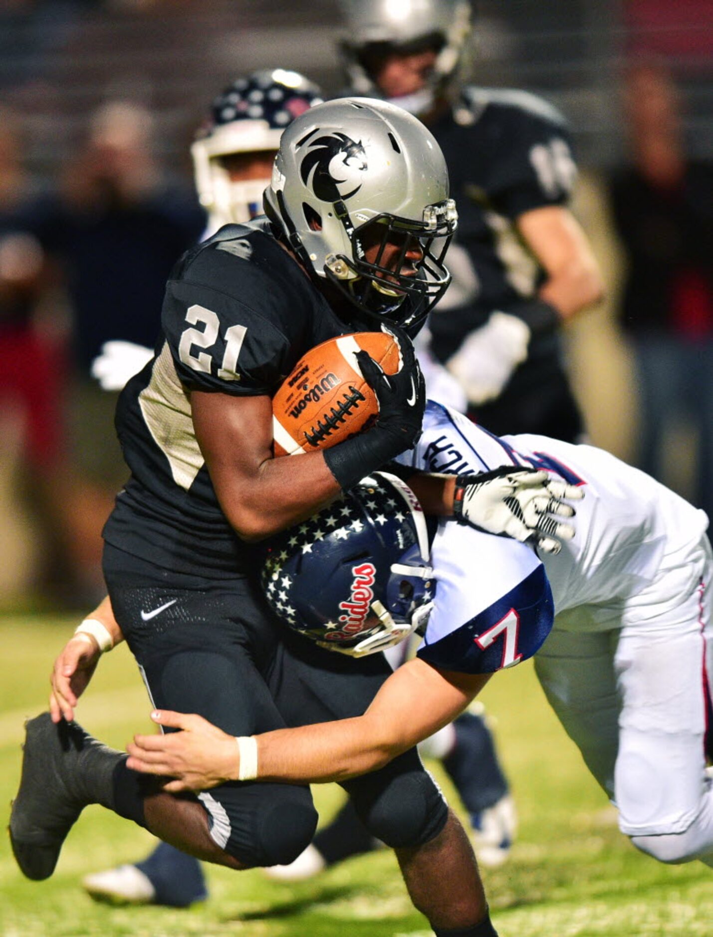 Guyer junior running back Christian Moore (21) is slammed by Ryan junior linebacker Toby...