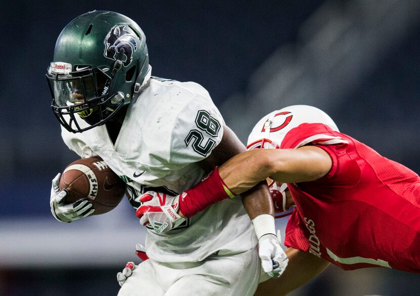 Kennedale running back DJ Kirven (28) is tackled by Carthage defensive back Ashton Hicks (1)...