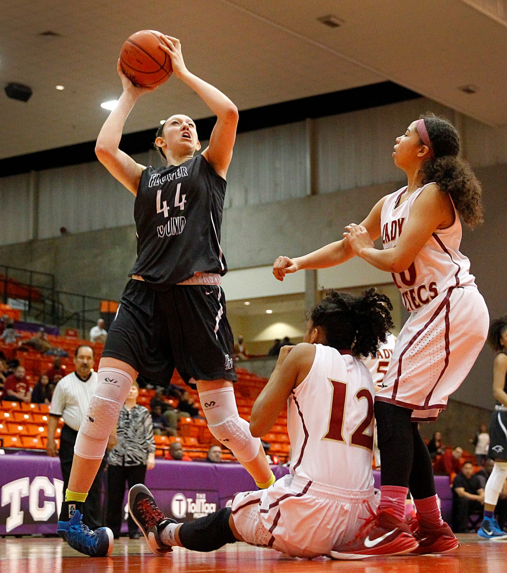 Flower Mound center Lauren Cox (44) rolls her ankle as she drives on El Paso El Dorado guard...