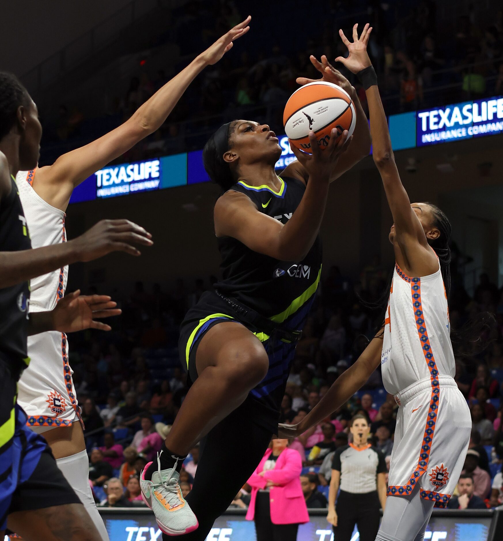 Dallas Wings center Teaira McCowan (7) drives hard to the basket as she splits a couple of...