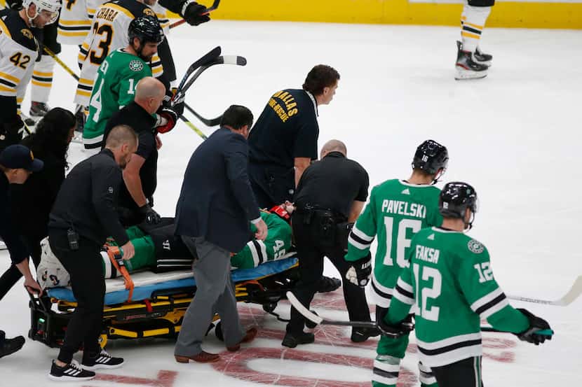 The medical team tends rolls injured player Dallas Stars defenseman Roman Polak (45) off the...
