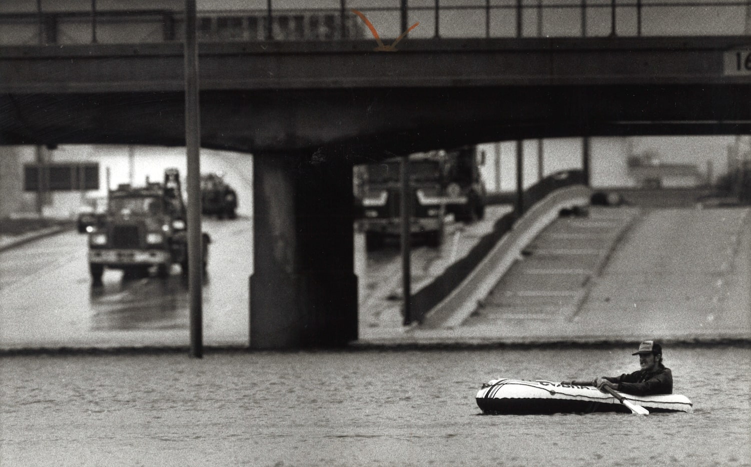 Michael Hoop of Houston uses a raft to cross flooded highway 225.