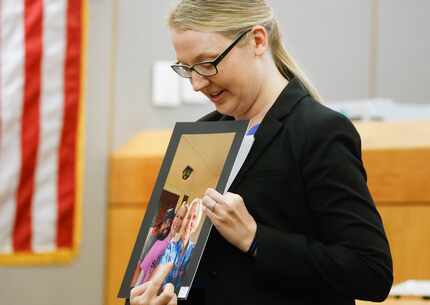 Prosecutor Hilary Wright points towards a family photo of slain 60-year-old Jasper resident...