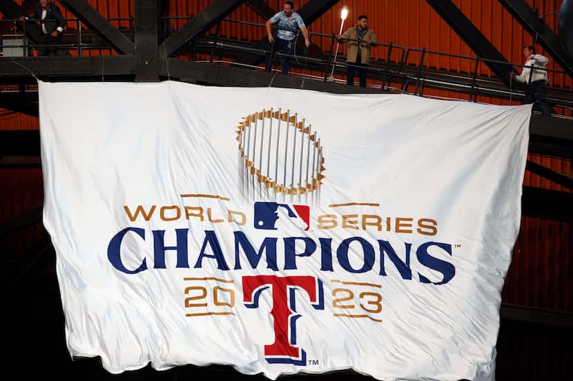 The Texas Rangers World Series Champions banner is unfurled from the rafters before the...
