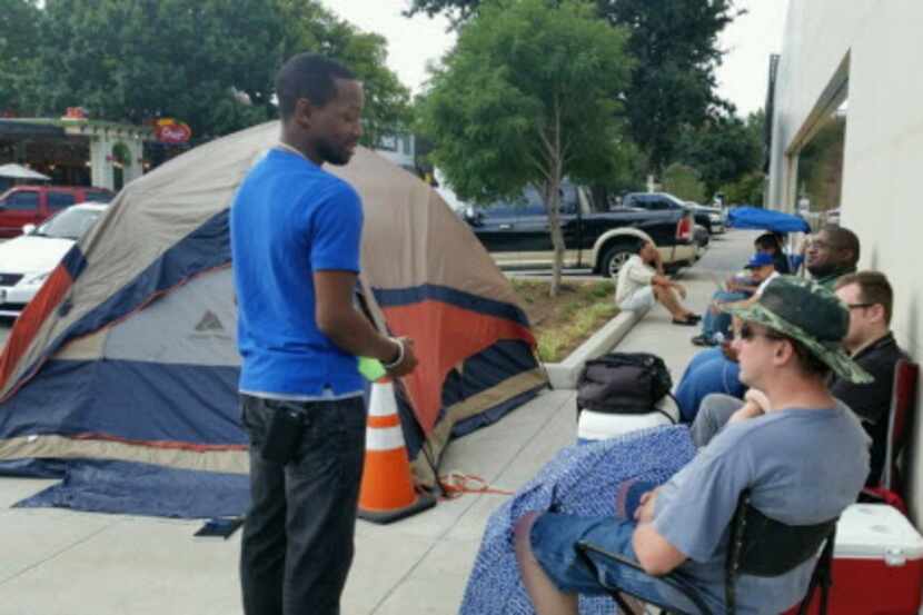 
An Apple store employee (left)  talks to Lyle Lathem, the first person in line at the store...