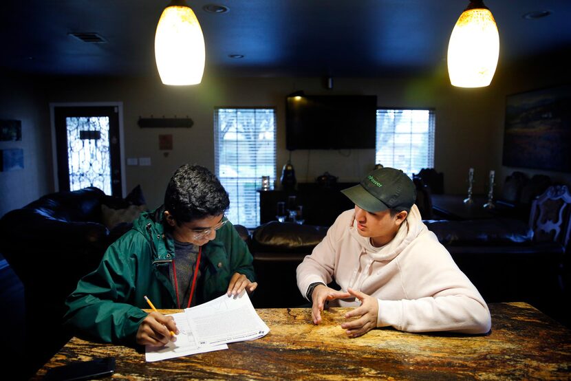 David Mojica (left), a freshman at Duncanville High School, receives some help on his...