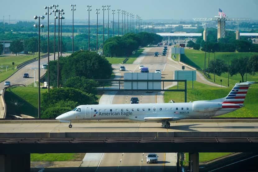 An American Eagle plane taxis on a bridge at DFW International Airport.