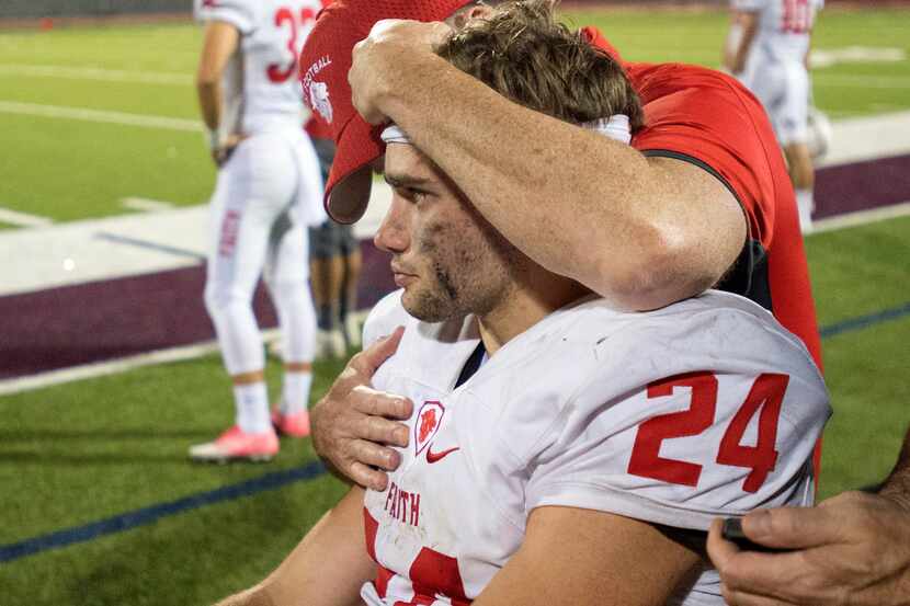Grapevine Faith Christian running back Preston Steele gets a hug from a coach after being...