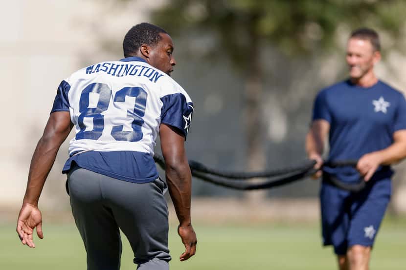 Dallas Cowboys wide receiver James Washington (83) trains on a resistance cord with director...