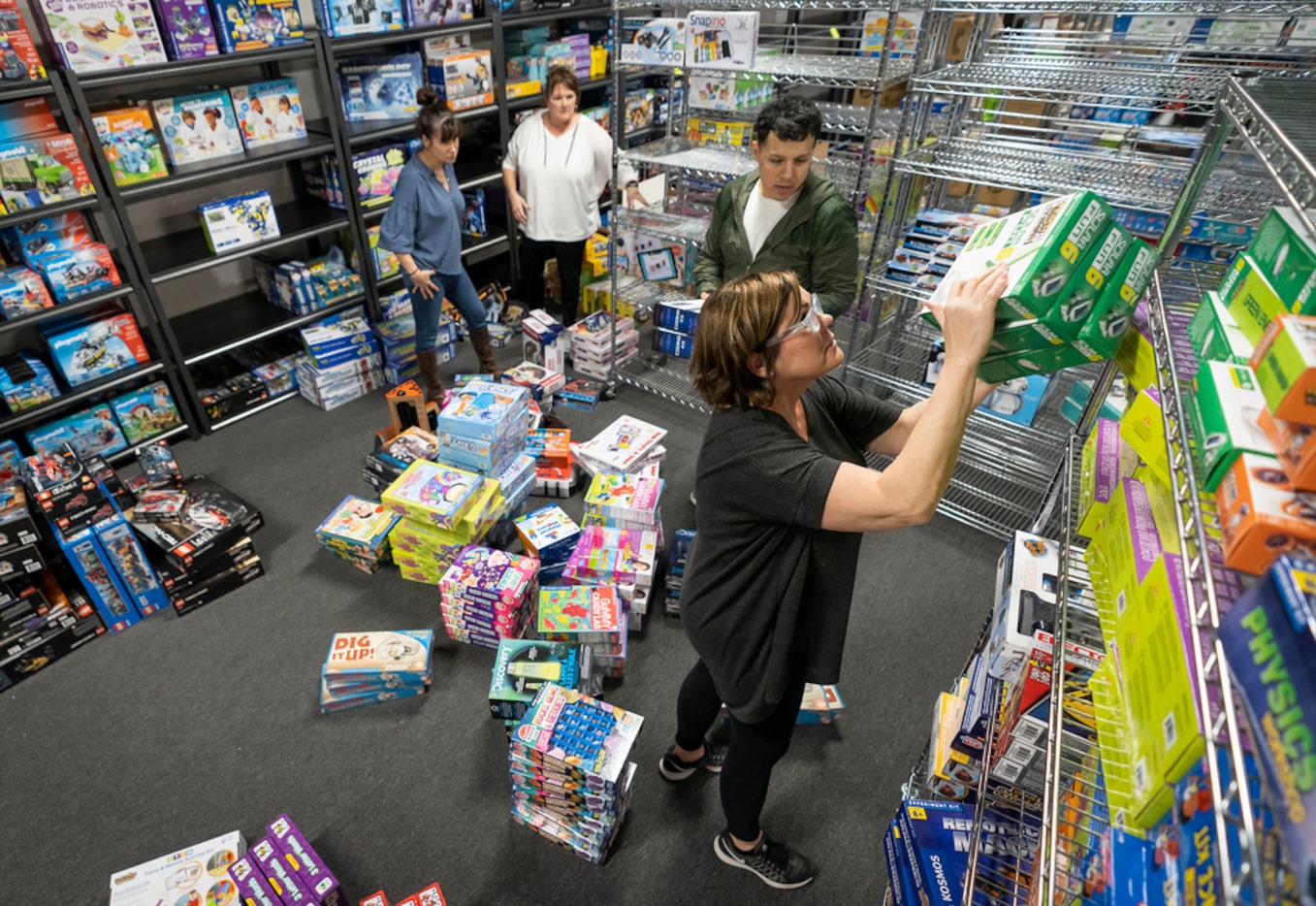 Laura January of McManemin Companies helps stock shelves with toys at a temporary location...