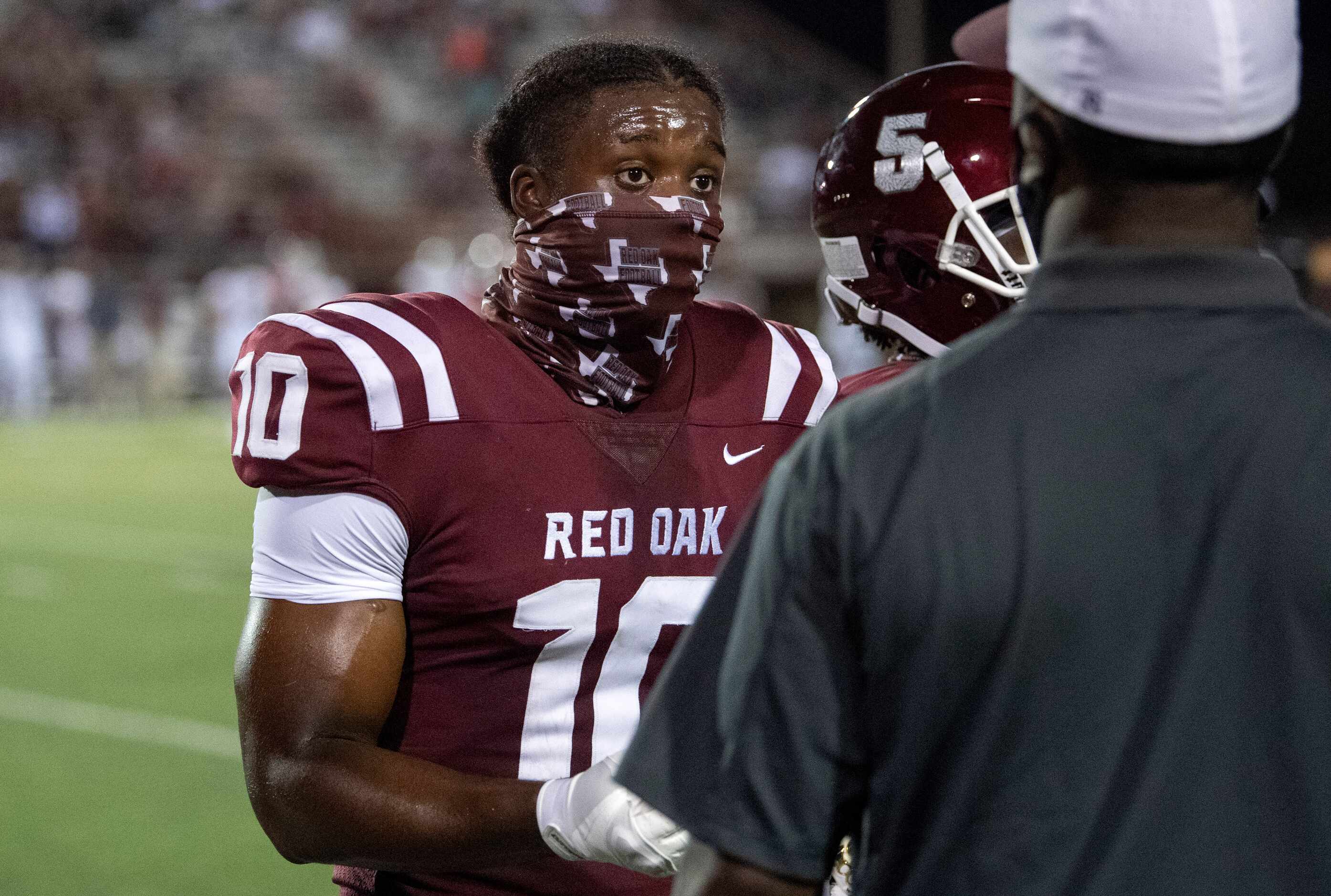 Red Oak senior Jaylyn Bennett (10) talks to a coach on the sidelines during the first half...