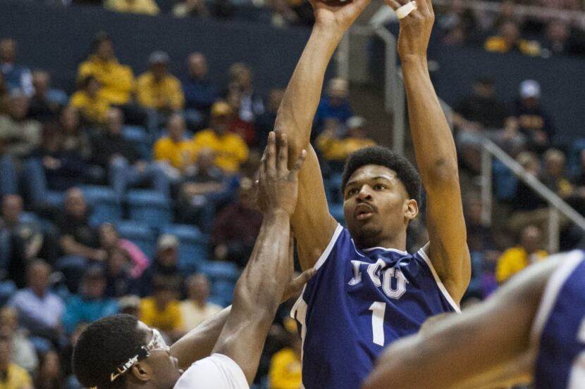 TCU's Karviar Shepherd, right, looks to shoot over West Virginia's Devin Williams during the...