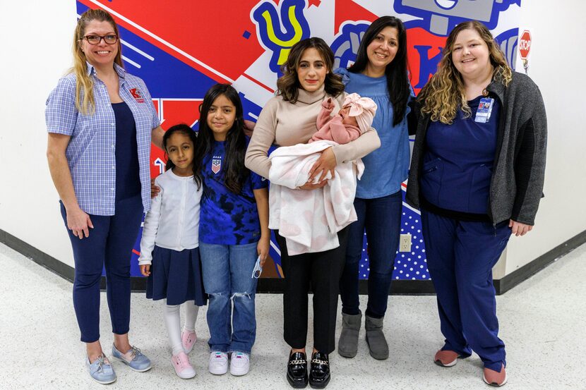 Loren Carcamo stands with her newborn daughter Leire, daughters Claire, 8, and Lorette, 6,...