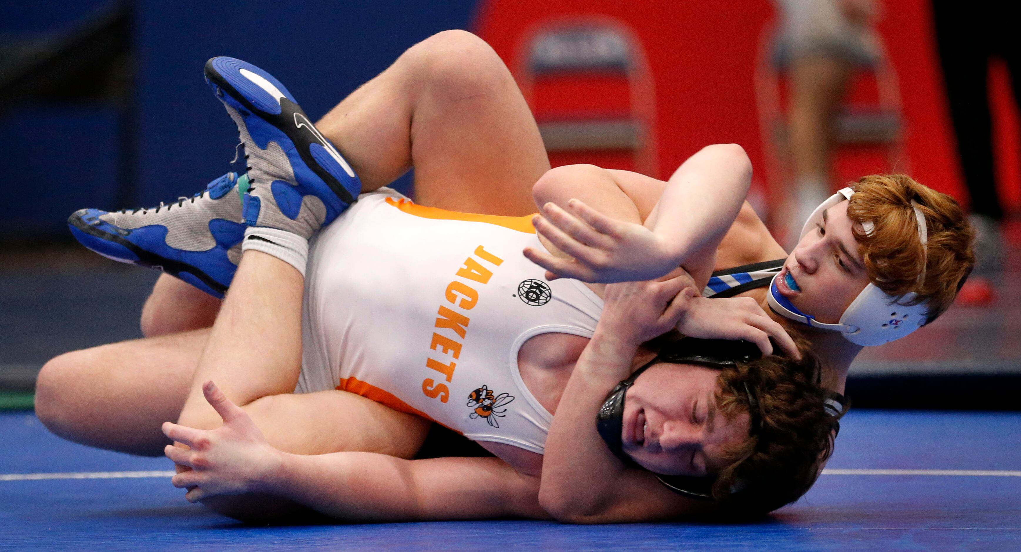 Plano West's Elijah Mundell puts Rockwall High wrestler Bryce Milster in a hold during their...