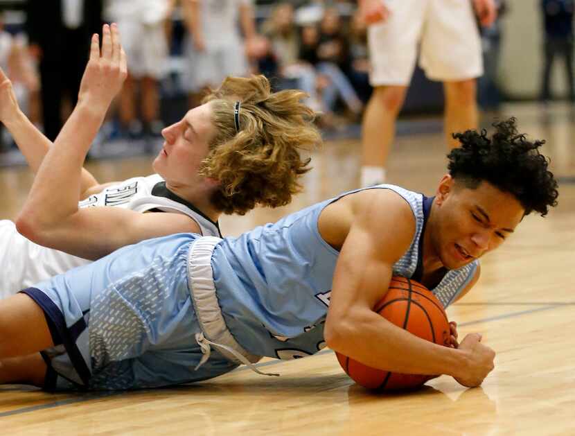 L.D. Bell's T.J. Barnes (right) gets a loose ball against Flower Mound's Caleb Lohner during...