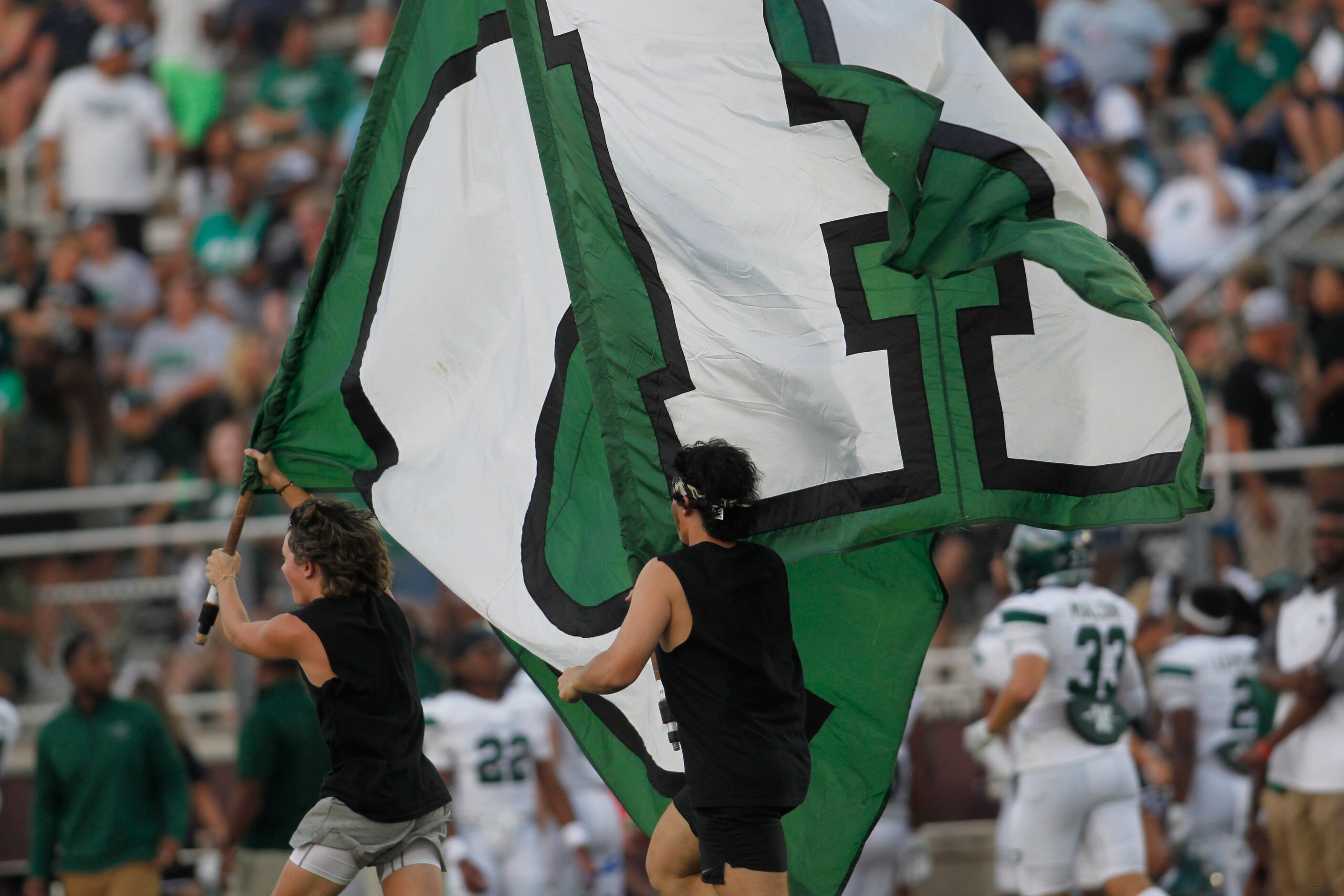 A couple of Waxahachie flag corps members race across the field in celebration of a first...