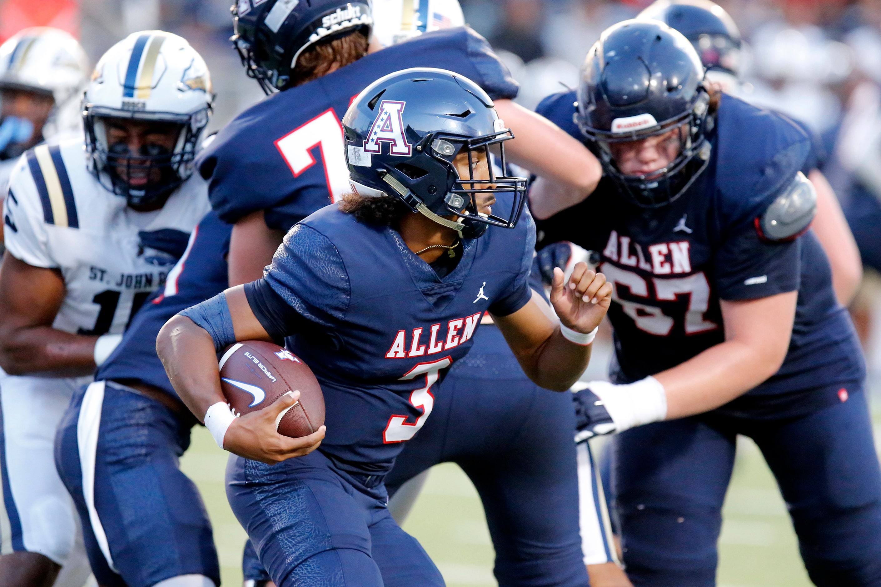 Allen High School quarterback Mike Hawkins (3) runs behind his offensive line during the...