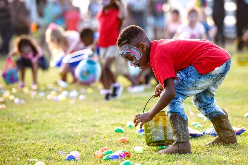 A child picks up eggs during an Easter egg hunt at Lindsey Park in Tyler, Texas, on...