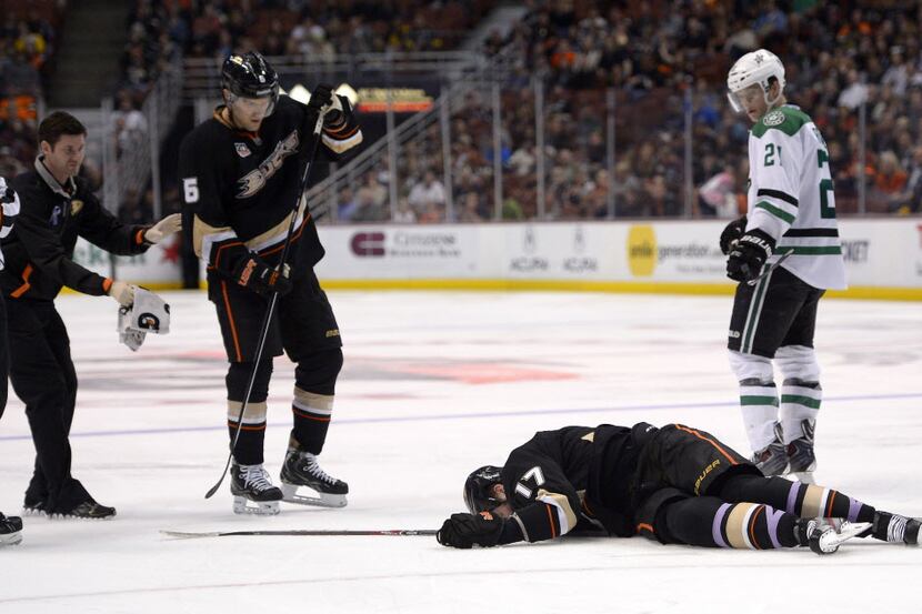 Anaheim Ducks left wing Dustin Penner, below, lays on the ice after being injured as...