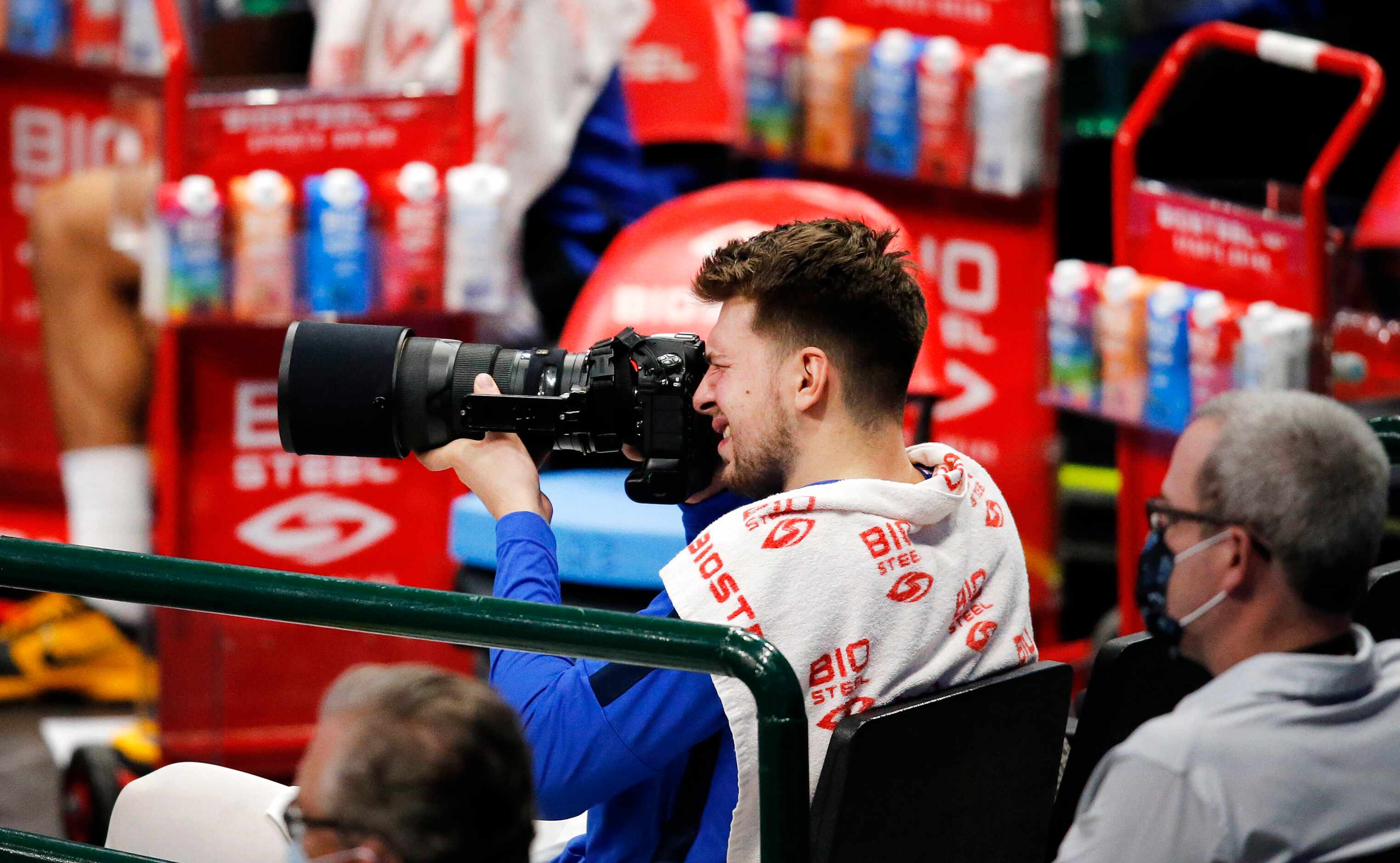 Sitting out in overtime, Dallas Mavericks guard Luka Doncic (77) picks ups a photographers's...