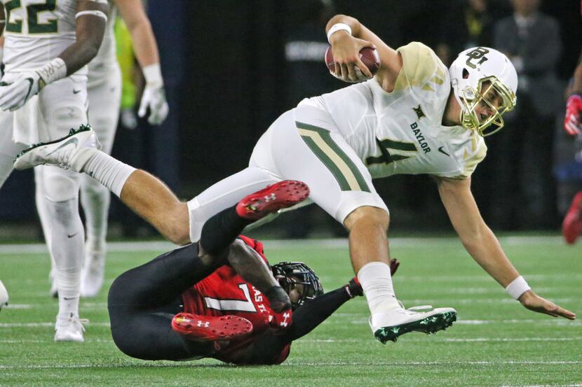 Baylor quarterback Zach Smith (4) tries to elude Texas Tech defensive back Jah'Shawn Johnson...