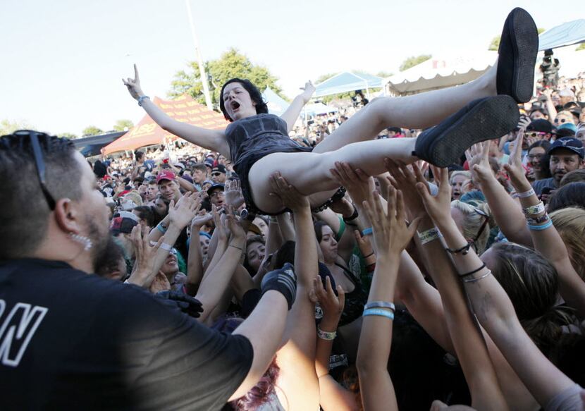 A young woman crowd surfs before being safely put to her feet by stage personnel during the...