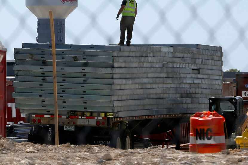 A construction worker y stanks on a heap of steal as thebuild Frisco Station in Frisco,...