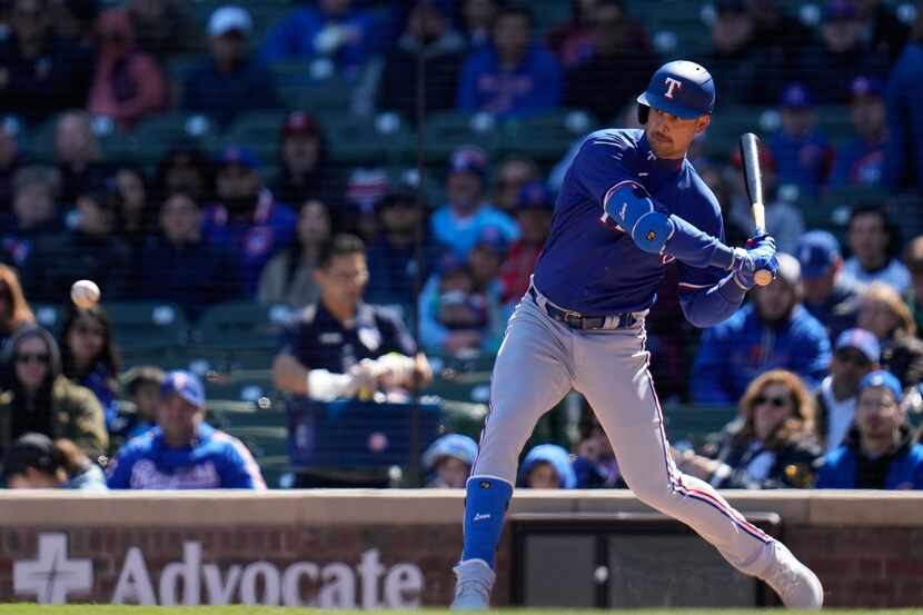 Texas Rangers first baseman Nathaniel Lowe hits a single during the first inning of a...