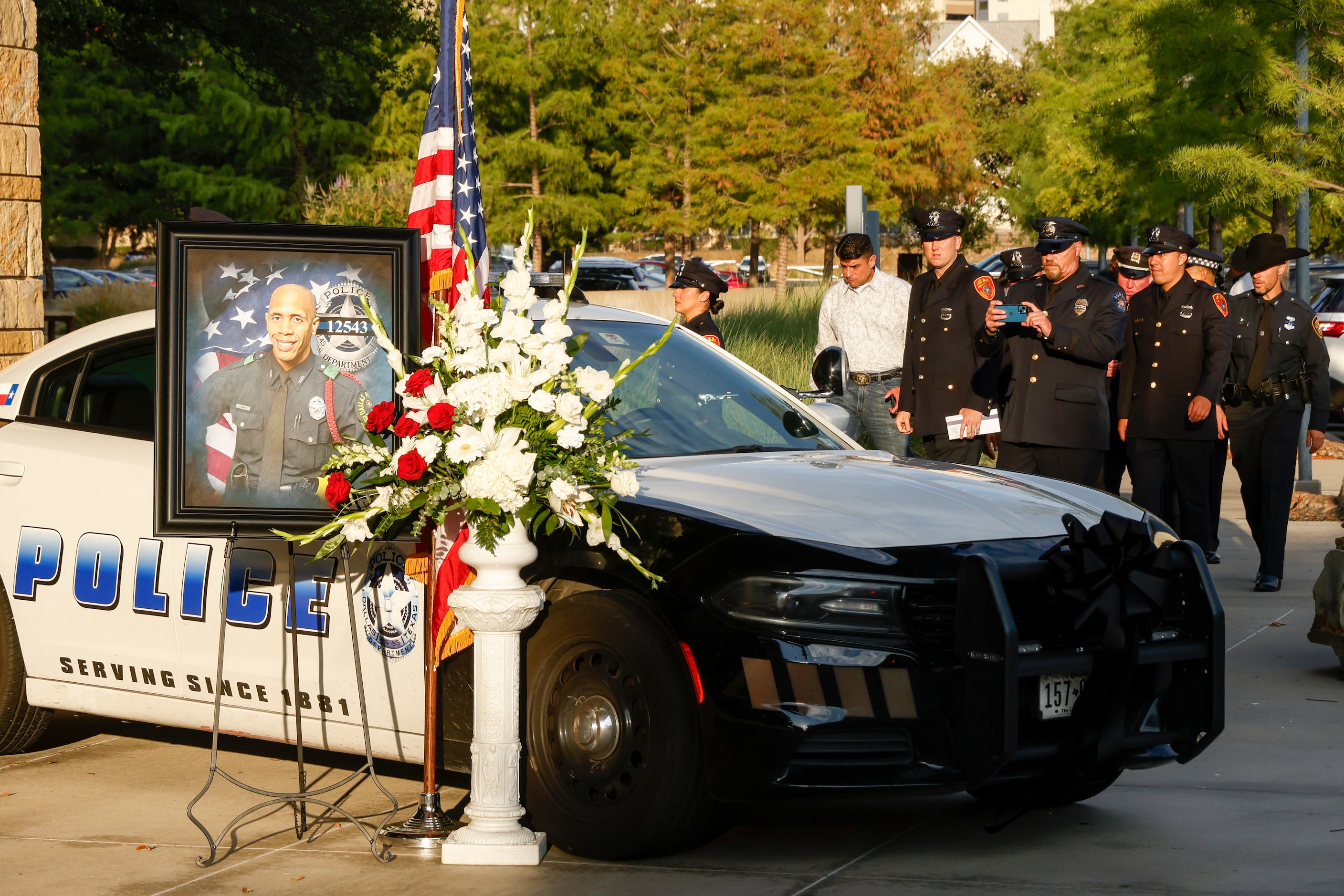 Police officers from various departments across the country take photos of a memorial for...