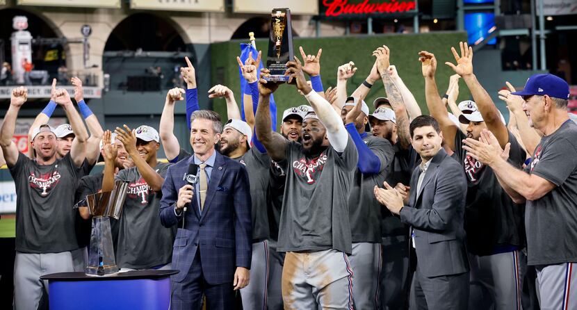 Texas Rangers right fielder Adolis Garcia (53) hoists the ALCS Most Valuable Player trophy...