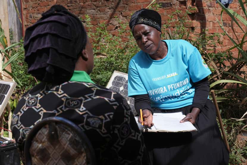 Siridzayi Dzukwa, a grandmother, right, talks to Tambudzai Tembo outside her house in...