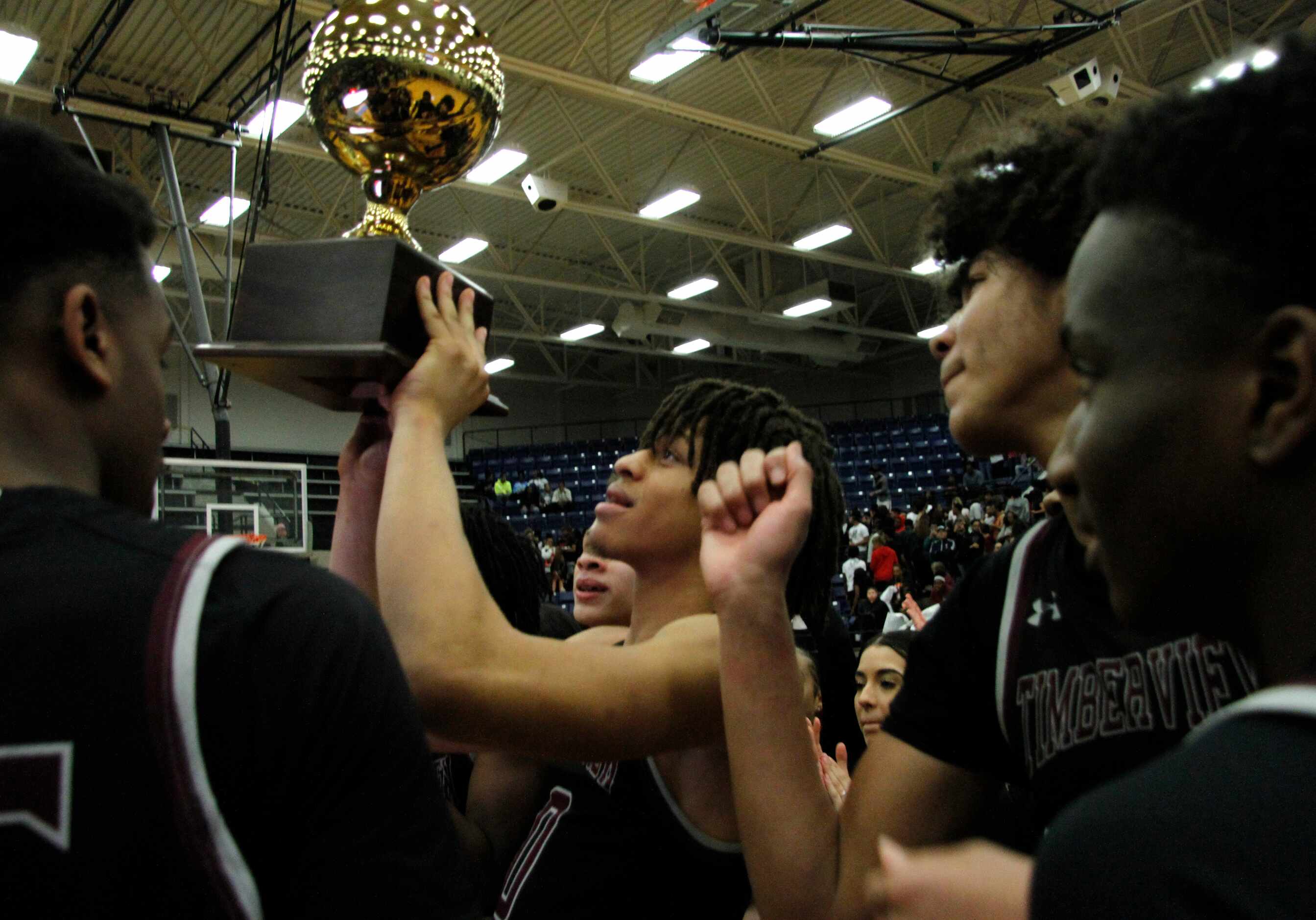 Members of the varsity boys basketball team at Mansfield Timberview gather at mid-court...