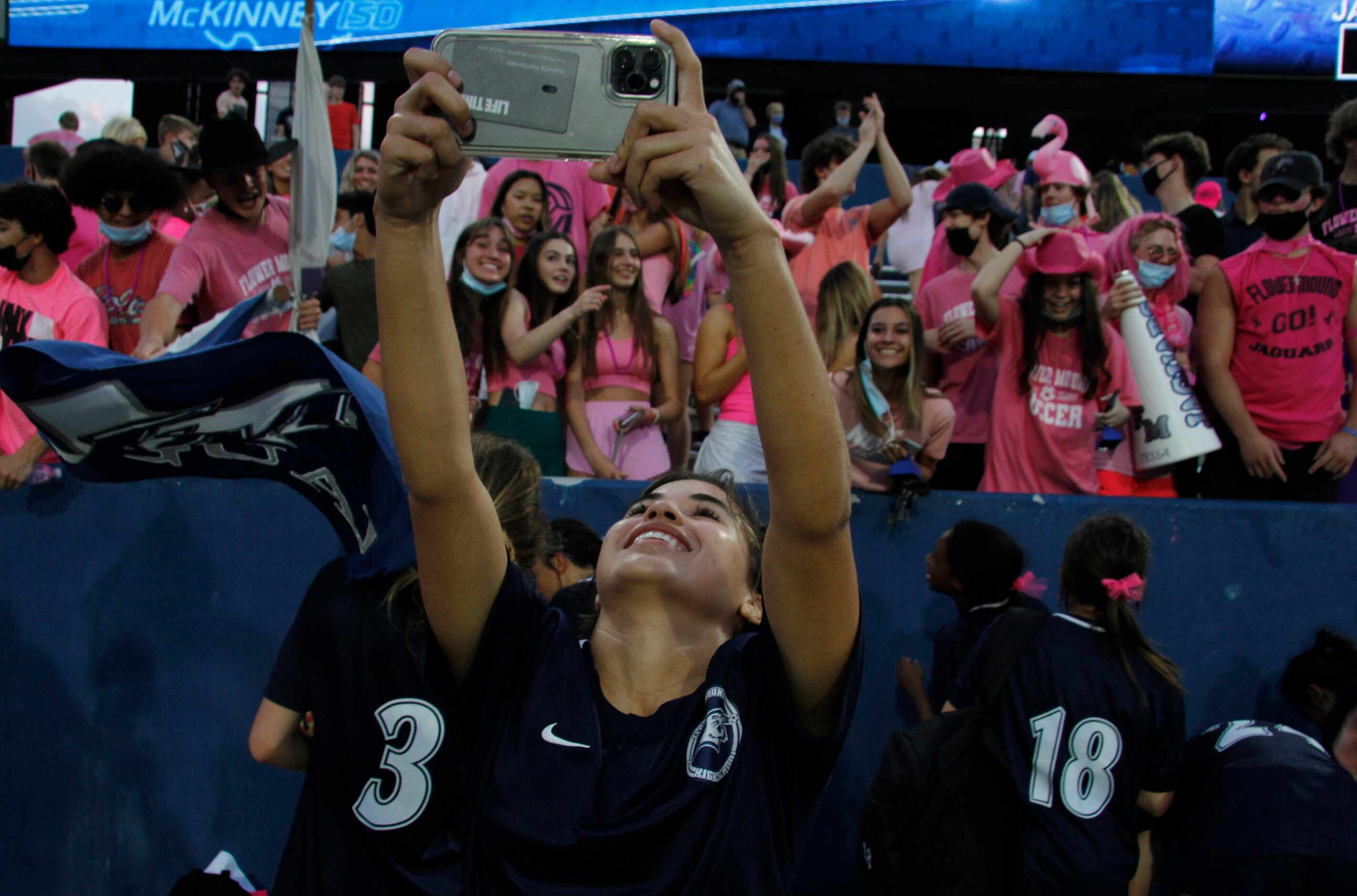 Flower Mound's Bella Hernandez(9) records the scene on her cellphone as players and fans in...