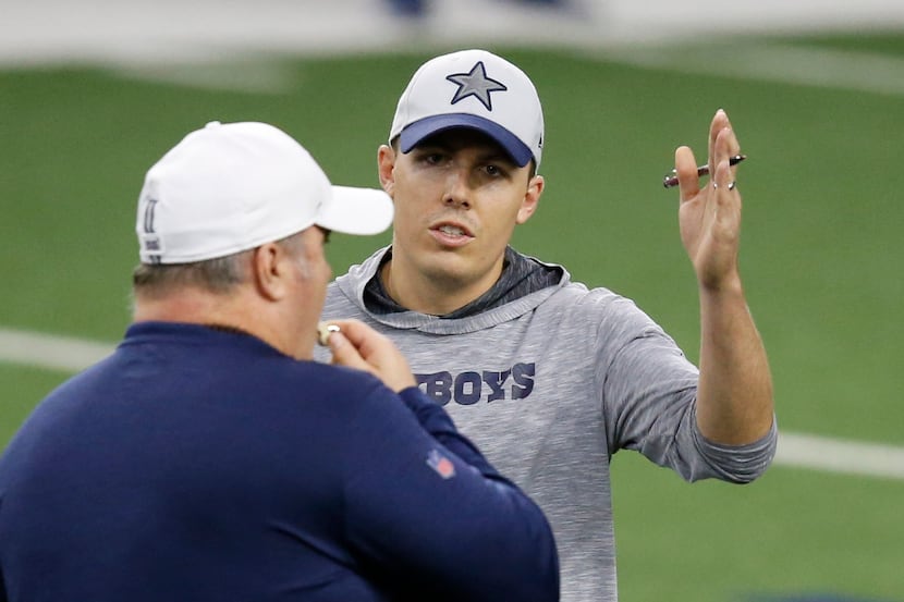 Head coach Mike McCarthy talks with Dallas Cowboys offensive coordinator Kellen Moore in...