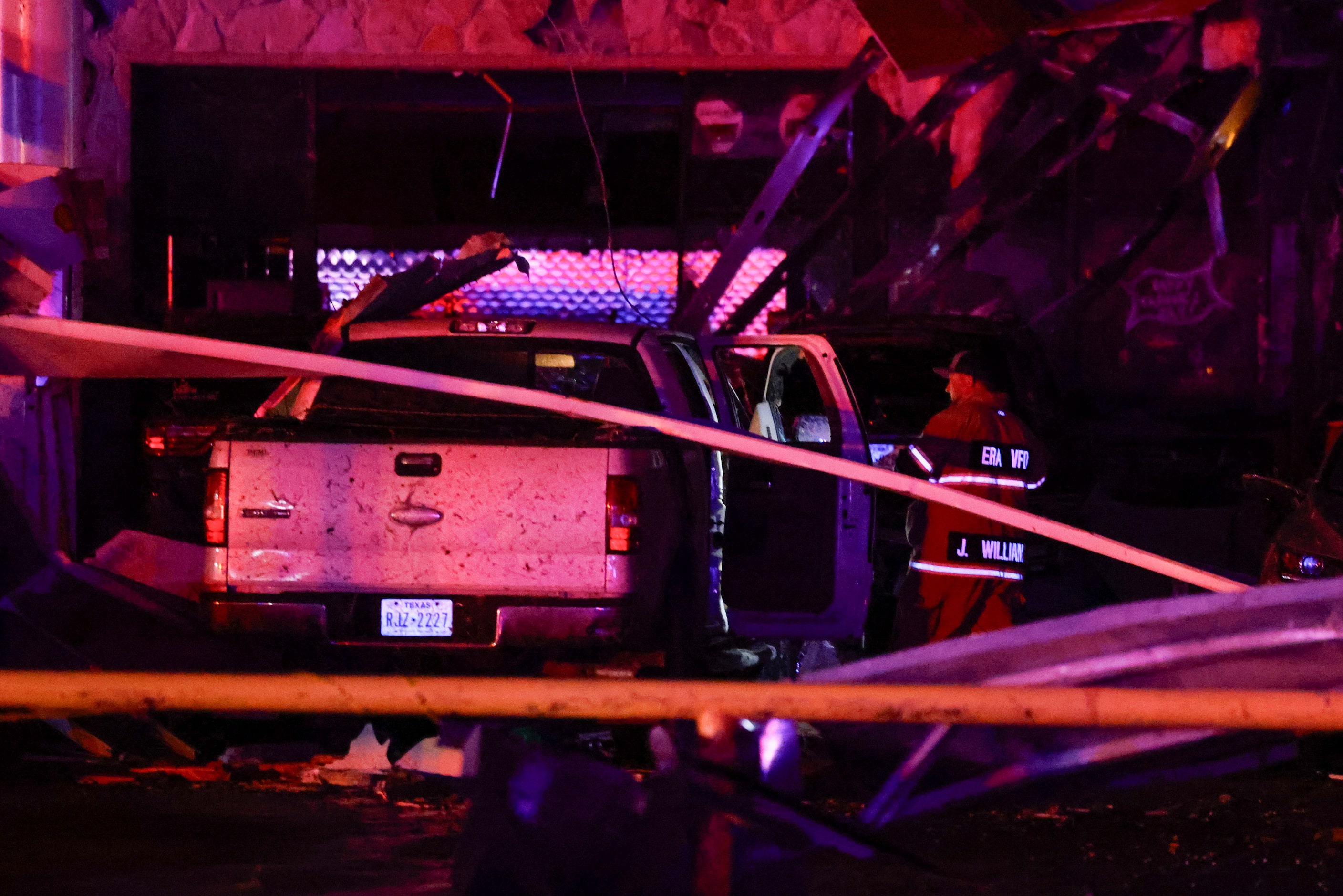 A firefighter checks inside a truck at a Shell gas station after a suspected tornado passed...