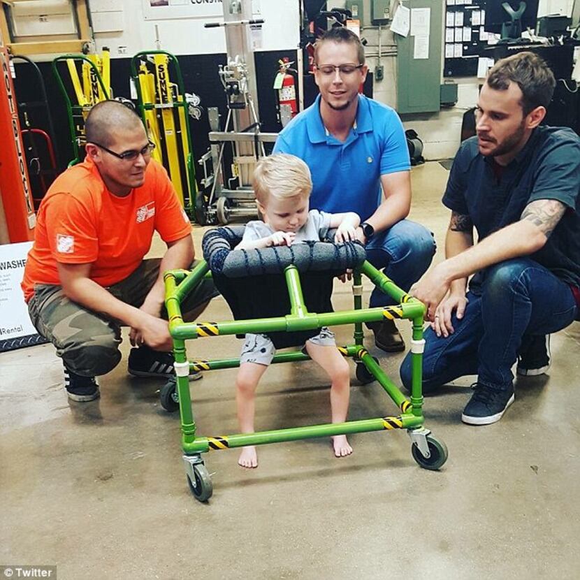 Silus Johnson, 2, is presented with a custom walker designed and built by three North...