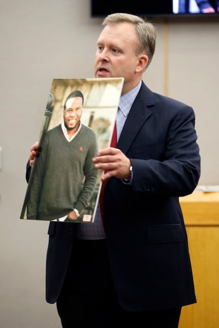 Assistant District Attorney Jason Hermus shows a photo of Botham Jean to the jury during his...