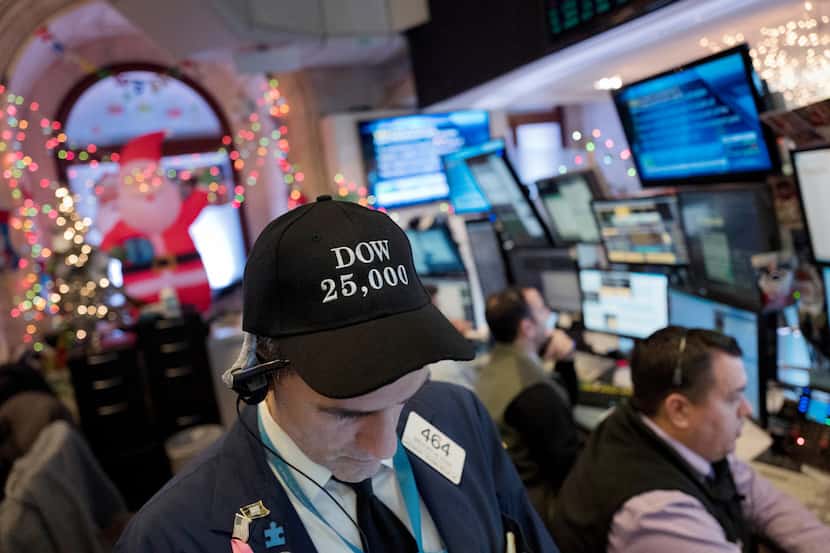 Stock trader Gregory Rowe wears a Dow 25,000 hat, Thursday, Jan. 4, 2018, at the New York...