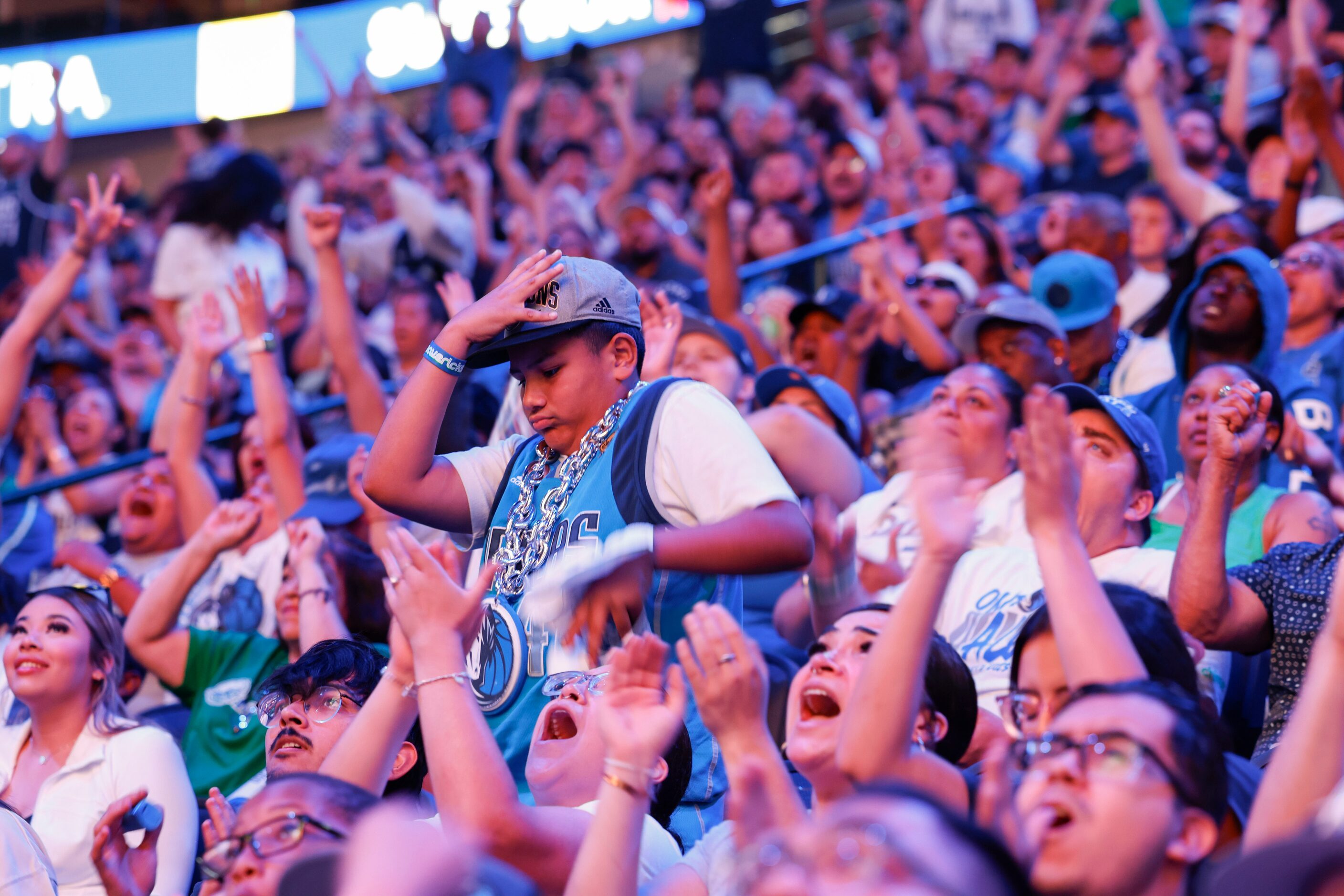 Damian Guerra, 10, (center), reacts as crowd cheer following a Dallas Mavericks point during...