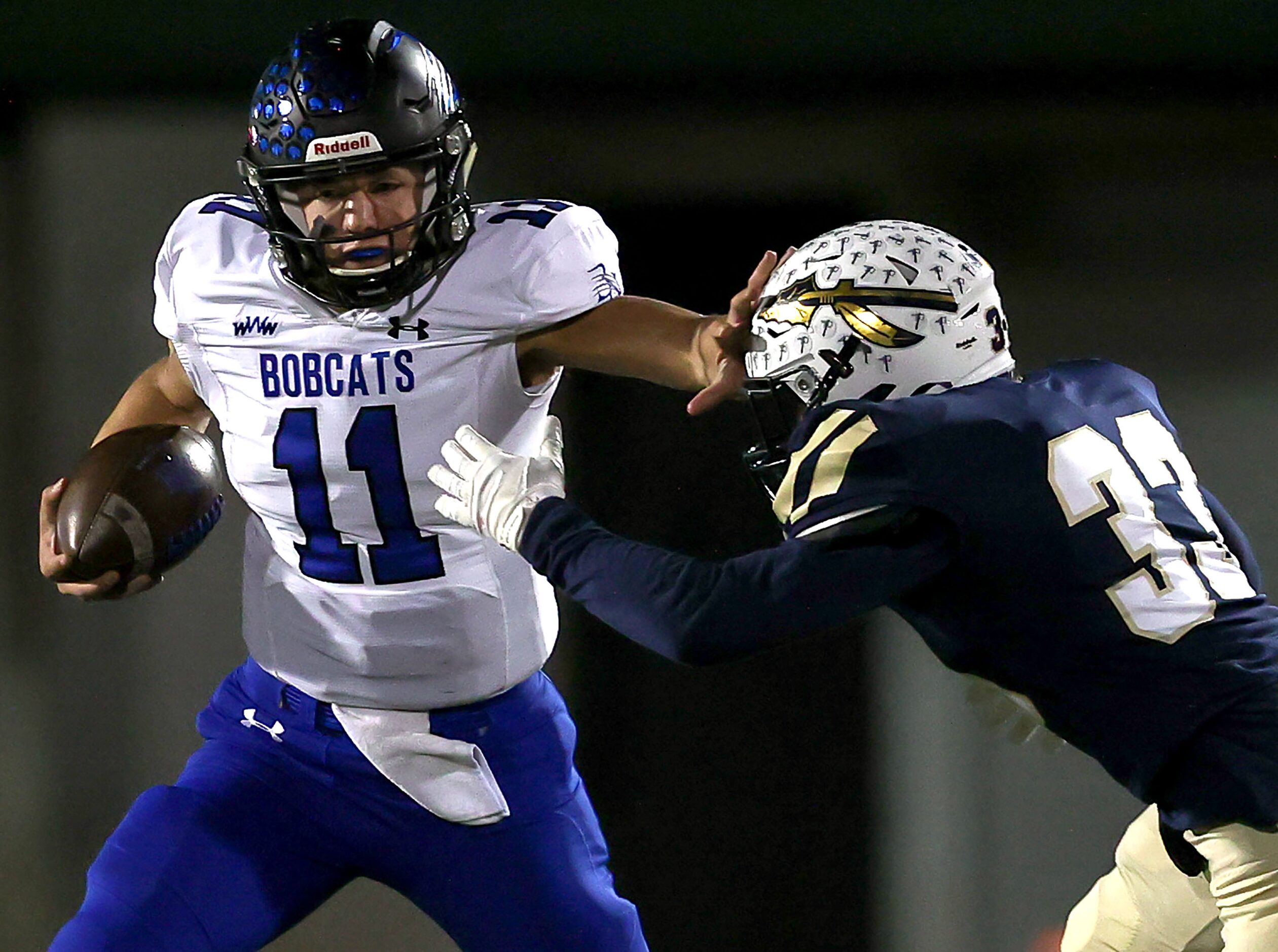 Byron Nelson quarterback Jacob Wilson (11) gives a stiff arm to Keller linebacker Treyce...