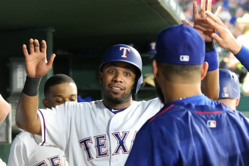 FILE - Texas Rangers shortstop Elvis Andrus (1) talks with pitcher Martin Perez, right, in...