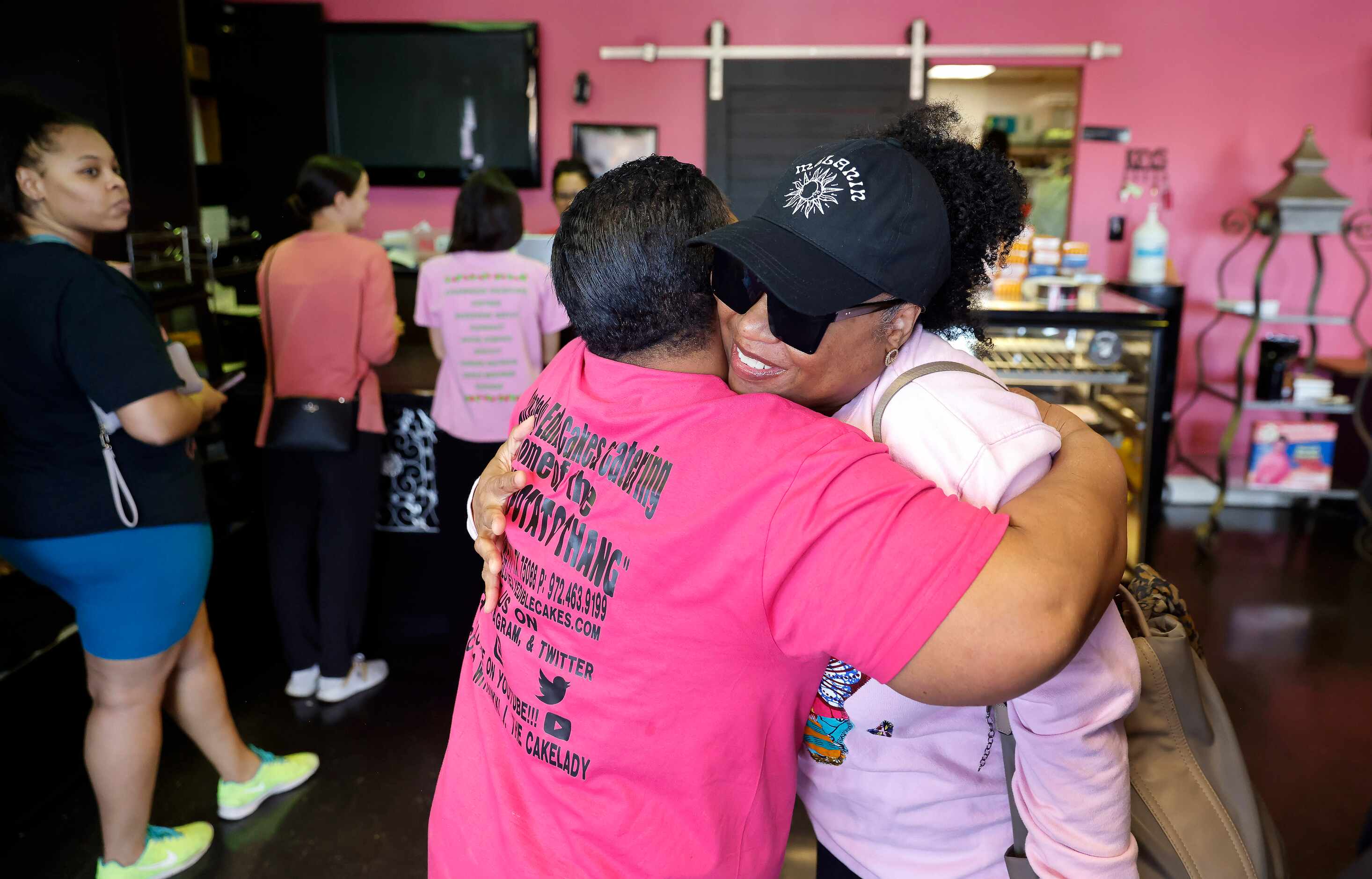 Business owner Nikki Jackson (left) receives a congratulatory hug from longtime friend and...