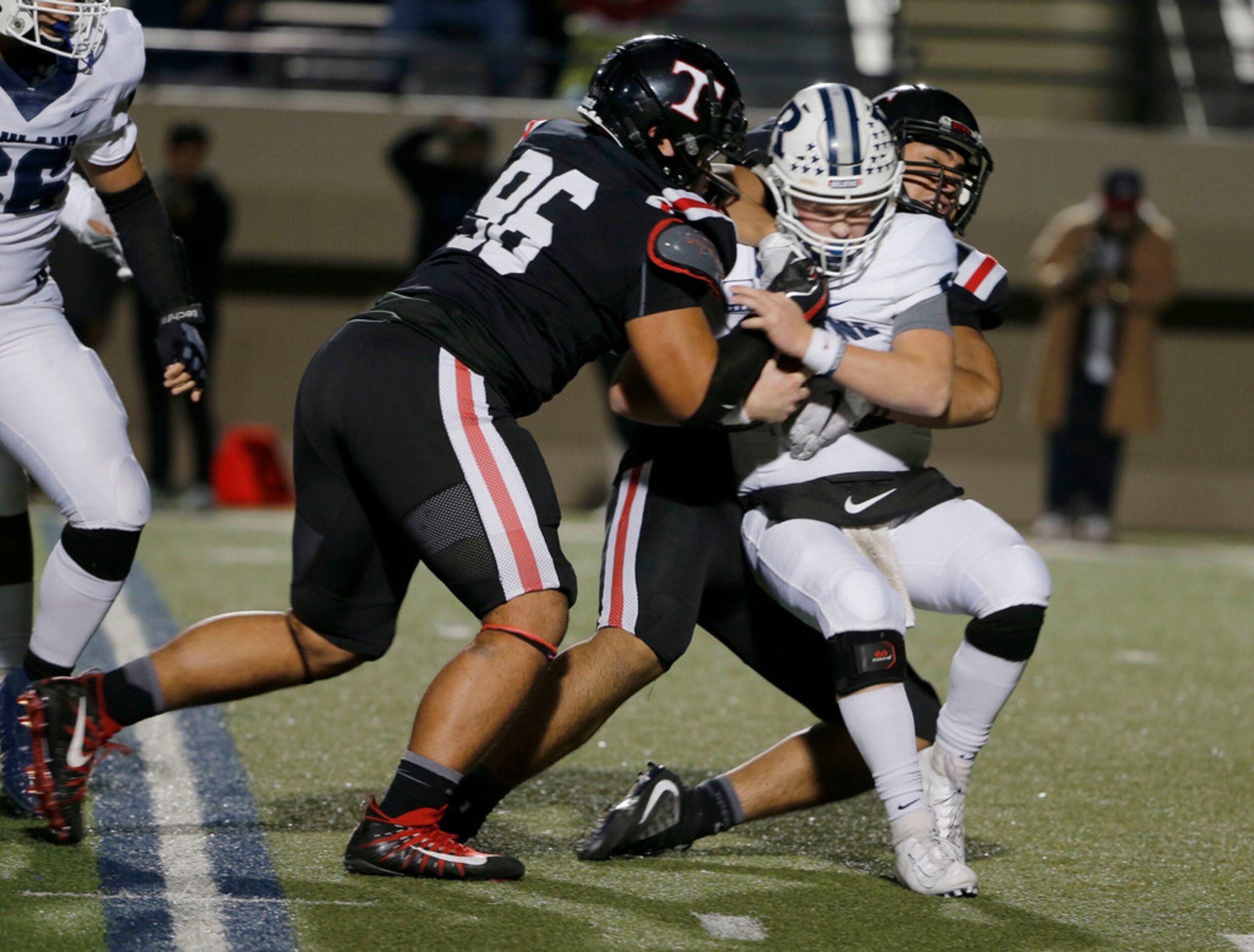 Trinity's Poukesi Vakauta (96) and Tonga Lolohea (54) tackle Richland quarterback Cole...