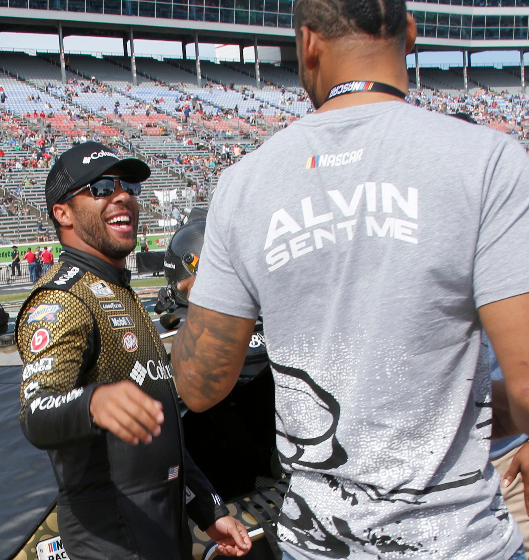 Driver Bubba Wallace, driver of the number 23 Toyota car, shares a light moment with a race...