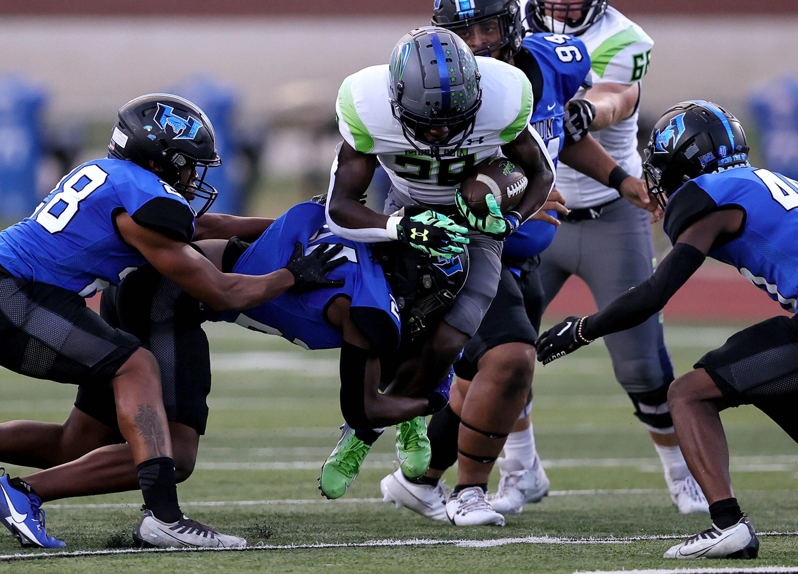 Eaton running back Demarion Williams (28) finds a small hole to run as he is tackled by...