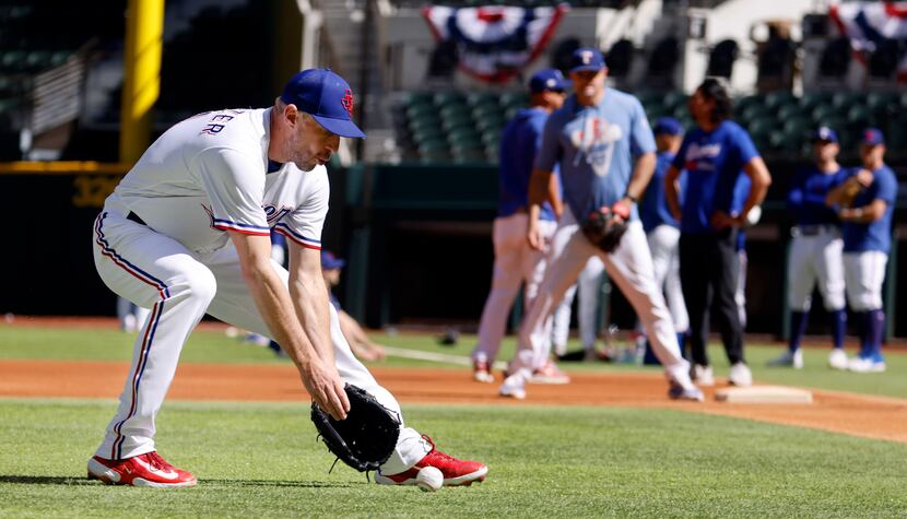 Texas Rangers starting pitcher Max Scherzer charges the ball on an infield hit during...