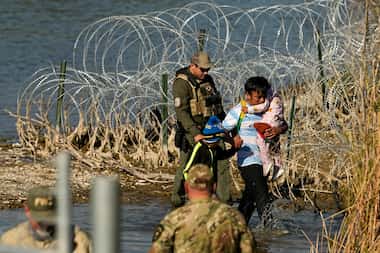 Migrants are taken into custody at the Texas-Mexico border, Jan. 3, 2024, in Eagle Pass. (AP...