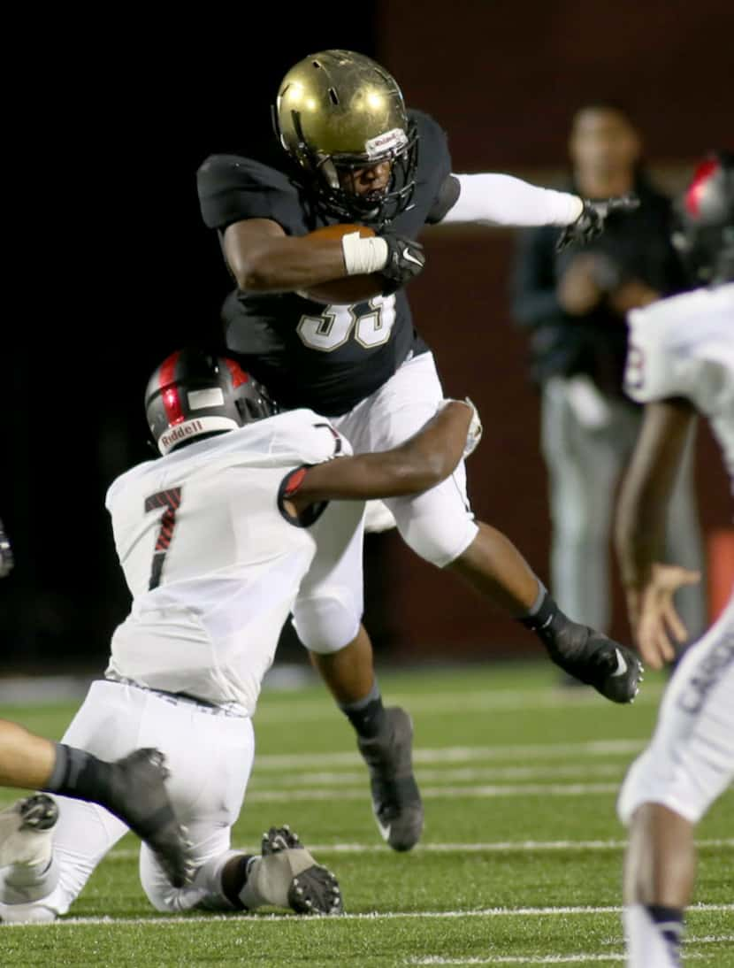 Irinvg’s James Miles, cq, 35, is tackled by MacArthur’s Tony MacDonald, cq, 7, during game...