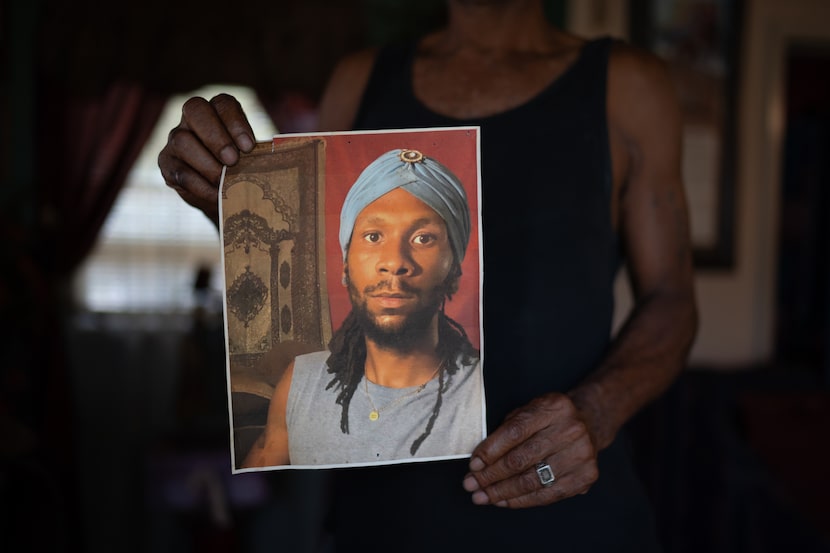 Emery Cobb holds a photo of his son, Corey Cobb-Bey, in their Dallas home on Aug. 31, 2024. 